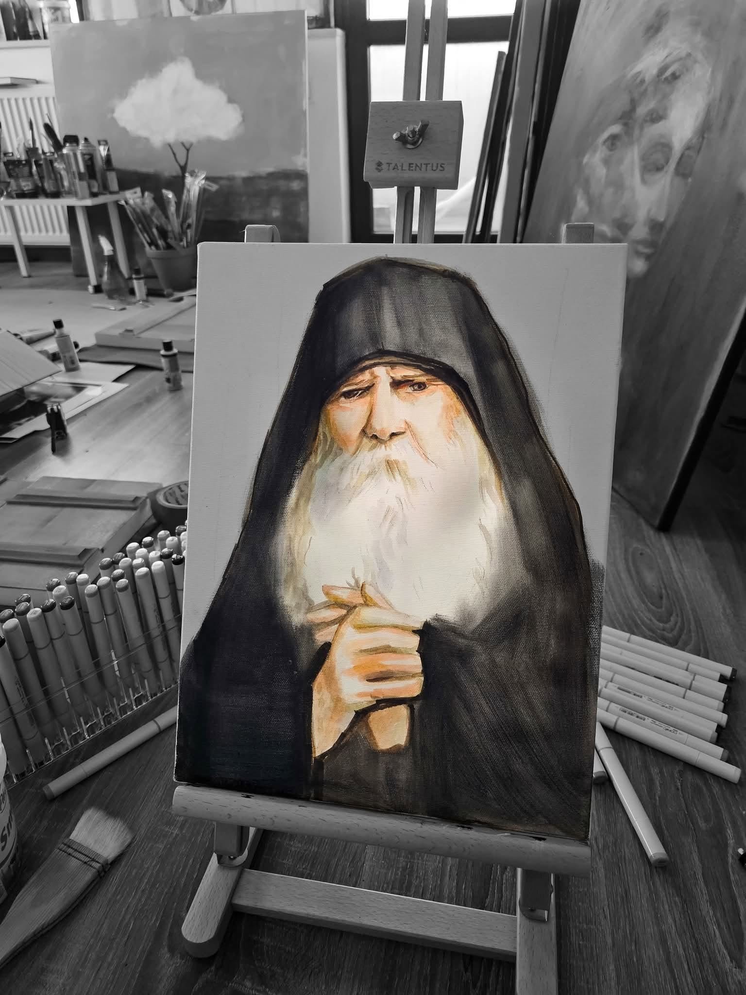 Portret de părinte așezat pe un șevalet mic, printre instrumente și alte picturi.