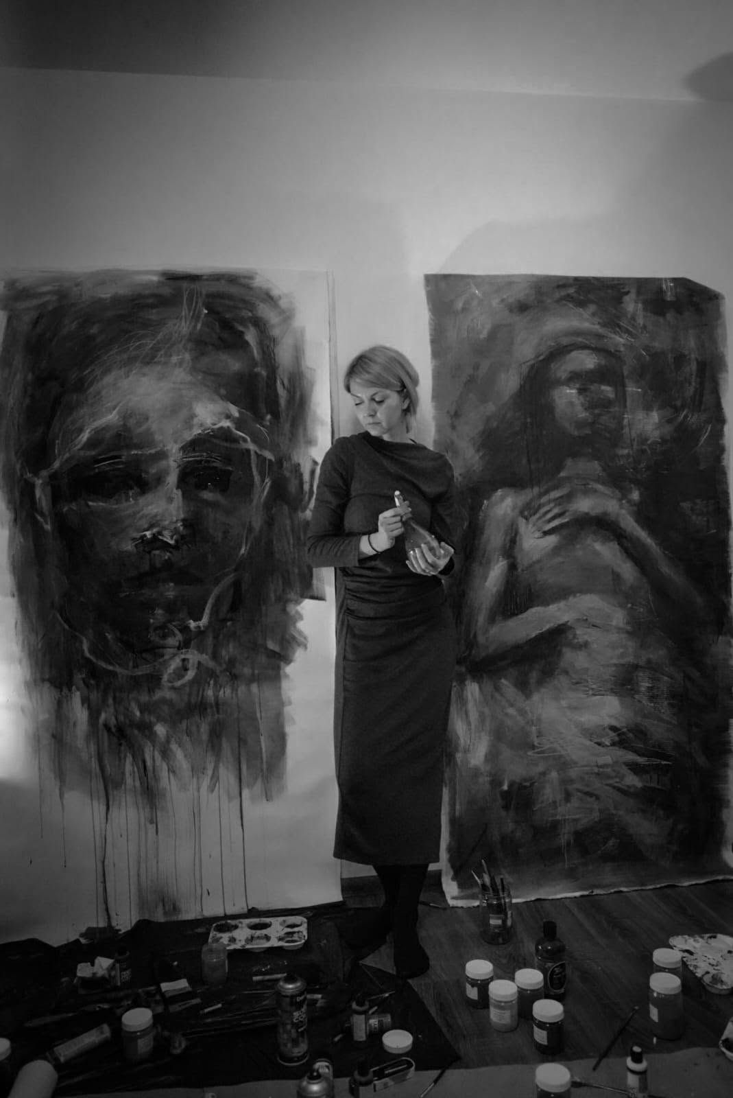 Artista în picioare între cele două lucrări în curs de realizare.